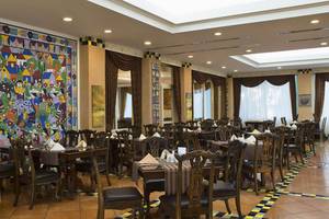 Restaurant im Delphin Diva Premiere Hotel mit bunten Wandgemälden und gedeckten Tischen.