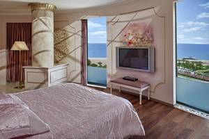 Schlafzimmer im Delphin Diva Premiere Hotel mit Meerblick und modernen Möbeln.