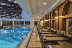 Im Delphin Diva Premiere Hotel gibt es einen großen Poolbereich mit Liegestühlen und einer Glasüberdachung.