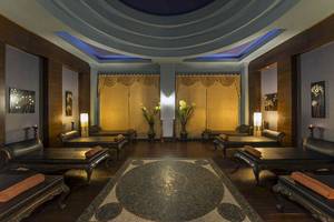 Spa-Lounge im Delphin Diva Premiere Hotel mit schwarzen Liegen und goldenen Vorhängen.