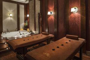Spa-Behandlungsraum im Delphin Diva Premiere Hotel mit zwei Massagebetten und einer Badewanne.