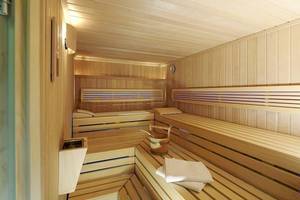 Innenansicht der Sauna im NH Berlin Alexanderplatz Hotel mit Holzbänken und Eimer.