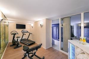 Fitnessraum im NH Berlin Alexanderplatz mit Trainingsgeräten und moderner Einrichtung.