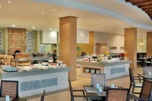 Innenansicht des Restaurants im Hilton Cabo Verde Sal Resort mit Buffet und Tischen.