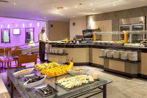 Buffet im Sol Lanzarote All Inclusive Hotel mit verschiedenen Speisen und einem Kellner, der serviert.