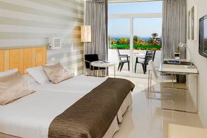 Innenansicht eines Hotelzimmers im H10 Lanzarote Princess mit Blick auf die Terrasse und das Meer.