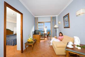 Innenansicht des AluaSoul Orotava Valley Hotels mit Frau auf Sofa und Meerblick