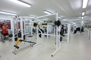 Fitnesscenter im AluaSoul Orotava Valley Hotel mit vielen Geräten und einem Mann, der Gewichte hebt.
