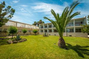 Außenbereich des Pavlina Beach Hotels mit gepflegtem Rasen und weißen Gebäuden