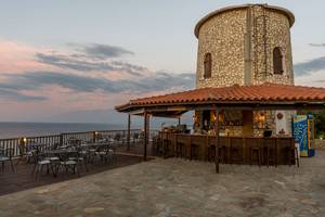Außenbereich der Pavlina Strand Bar bei Sonnenuntergang mit Blick auf das Meer
