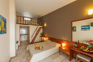 Ein Hotelzimmer von Pavlina Beach mit einem Doppelbett, Balkon, und Frühstücksangebot.
