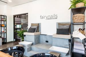 Innenansicht des FairyNails Original Nailbars Salons mit zwei Sitzbereichen und Waschbecken.