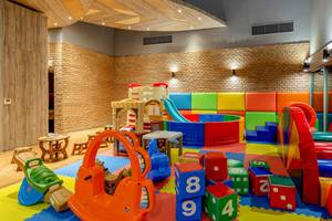 Kinderspielbereich im Kalima Resort & Villas Khao Lak mit bunten Spielgeräten und Spielzeug.