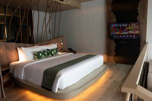 Schlafzimmer im Kalima Resort & Villas Khao Lak mit Kingsize-Bett, Fernseher und Nachttisch