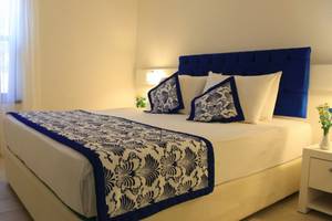 Hotelzimmer im LABRANDA Ephesus Princess mit weißem Bett und blauen Kissen