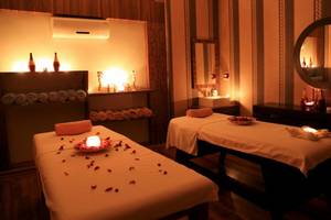 Massage-Behandlungsraum im LABRANDA Ephesus Princess Hotel mit zwei Behandlungstischen, Kerzen und Rosenblättern.