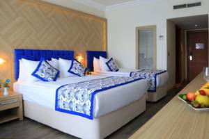 Doppelzimmer im LABRANDA Ephesus Princess Hotel mit zwei Betten, Früchten und Getränken.