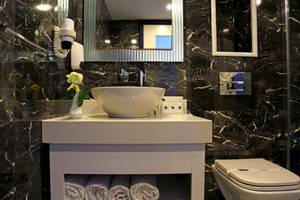 Badezimmer im LABRANDA Ephesus Princess Hotel mit schwarzem Marmor und weißen Möbeln.