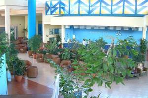 Lobby des Muthu Playa Varadero Hotels mit vielen Pflanzen und Sitzgelegenheiten.