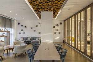 Innenbereich des Cavo Maris Beach Hotels mit moderner Einrichtung, Holzmöbeln und Glaselementen.