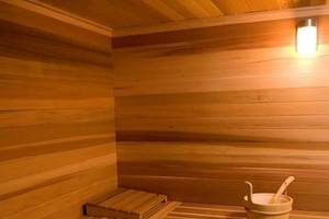 Innenansicht einer Sauna im Queens Bay Hotel mit Holzwänden und Sitzbänken.