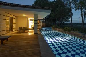 Nachtansicht des Infinity-Pools des Kempinski Hotel The Dome Belek mit beleuchteter Terrasse.