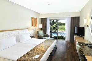 Luxuriöses Zimmer im Kempinski Hotel The Dome Belek mit Doppelbett, Aussicht auf den Pool und moderner Einrichtung.