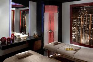 Spa-Behandlungsraum im Kempinski Hotel The Dome Belek mit zwei Massageliegen, Waschbecken und Wanddekoration.
