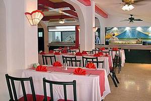 Innenansicht des Restaurants im Muthu Playa Varadero Hotel mit gedeckelten Tischen und Stühlen.