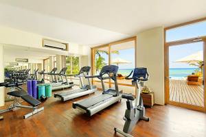 Fitnessraum im Melia Zanzibar mit Blick auf das Meer und eine Terrasse.