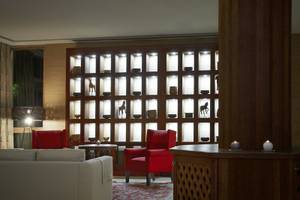 Loungebereich des Melia Zanzibar Hotels mit roten Sesseln und einer beleuchteten Wand.