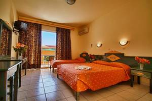 Hotelzimmer im Ilios K. Village Resort mit zwei Betten, Fernseher und Balkon.