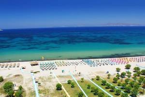 Ilios K. Village Resort Strand mit vielen Sonnenschirmen und Liegen