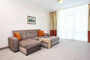 Wohnzimmer im Festa Panorama Hotel mit Sofa, Couchtisch und Fernseher.
