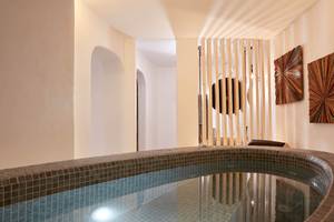 Innenpool im Absolute Mykonos Suites & More Hotel mit gefliesten Wänden und Boden.