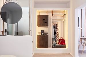 Innenraum von Absolute Mykonos Suites & More mit offenem Schrank und Kleidern.