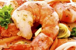 Gegrillte Garnelen mit Zwiebeln und Petersilie auf einem Teller serviert