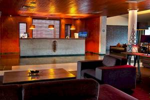 Empfangsbereich des Catalonia Royal Bavaro Hotels mit Rezeptionstresen, Sitzbereich und Fernseher.