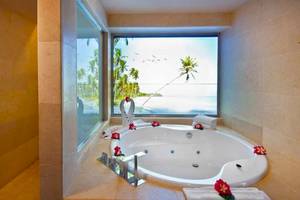 Ein Badezimmer im Catalonia Royal Bavaro Hotel mit großer Badewanne und Panoramafenster zum Meer.