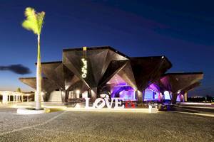 Nachtansicht des Grand Palladium Costa Mujeres Resort & Spa mit einer großen LOVE-Installation vor der Bühne.