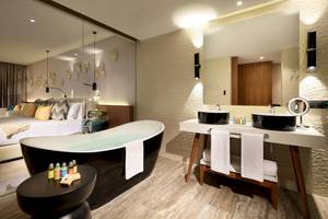 Badezimmer im Grand Palladium Costa Mujeres Resort mit Badewanne, Waschbecken und Bett im Hintergrund.