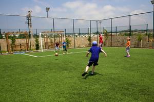 Kinder stoßen Fußball auf Rasen im Eftalia Aqua Resort Hotel