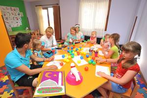Gruppe von Kindern und Erwachsenen, die in einem farbenfrohen Raum basteln, im Eftalia Aqua Resort.