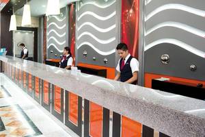 Rezeption des Riu Caribe Hotels mit Marmortheke und modernen Wandgestaltungen