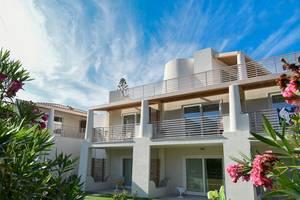 Außenansicht des Baia del Sole Hotels mit Balkonen, Rasen und Blumen im Vordergrund