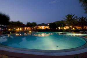 Nachtansicht des Swimmingpools des Baia del Sole Hotels, beleuchtet und umgeben von Bäumen
