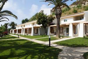 Reihe von Gebäuden des Baia del Sole Hotels mit Terrassen und Palmen im Vordergrund