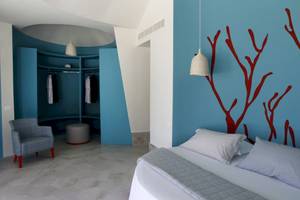 Schlafzimmer im Baia del Sole Hotel mit blauen Wänden und roten Wanddekorationen.