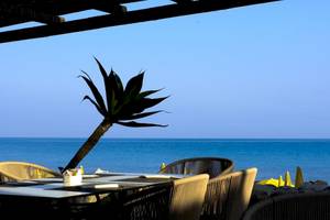 Terrasse des Baia del Sole Hotels mit Blick auf das Meer und gelbe Sonnenschirme.
