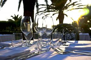 Tisch mit Gläsern und Besteck auf Baia del Sole, vor Sonnenuntergang